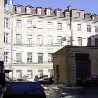 На фото: часть фасада 4‑этажного здания с мансардным этажом, примыкающая дворовая территория, здание ТП, припаркованные автомобили