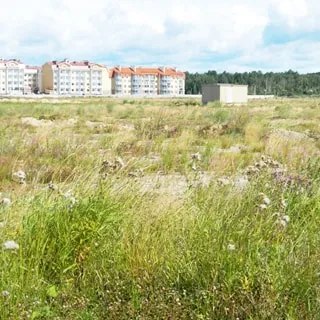 На фото: земельный участок, луговой, пустой, не застроен, на участке - трансформаторная подстанция, на дальнем плане - жилая застройка и лесополоса