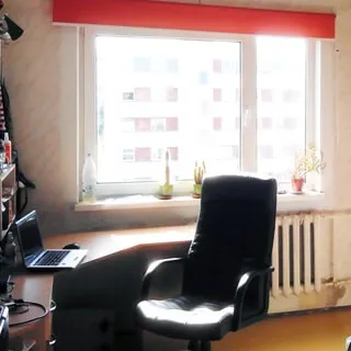 На фото: часть помещения жилой комнаты, одно окно, установлен стеклопакет, под окном - батарея центрального отопления, сева у окна в углу - компьютерный стол и офисное кресло, на столе - портативный компьютер