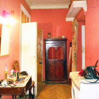 На фото: часть помещения прихожей, прямо у стены - шкаф, слева в углу - открытая дверь, слева у стены - столик и зеркало над ним, справа у стены - стиральная машина, полы - паркет