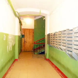 На фото: помещение лестничной клетки первого этажа, справа на стене - сблокированные почтовые ящики, прямо впереди - лестница с металлическими перилами, полы - керамическая плитка, стены - окрашены не в полную высоту