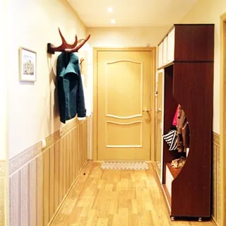На фото: часть помещения прихожей, входная дверь, слева на стене - оленьи рога в качестве вешалки, справа вдоль стены - одежный шкаф, вешалка для верхней одежды и тумба для обуви