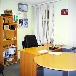 На фото: часть помещения нежилого помещения офисного типа, офисная мебель (книжный шкаф открытого типа, письменный стол, офисные кресла и стулья), принтер, на окне - вертикальные жалюзи