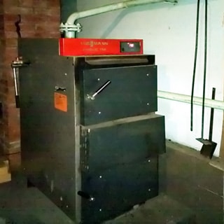 На фото: часть хозяйственного помещения, на полу установлен газогенераторный котел Viessmann на древесном топливе