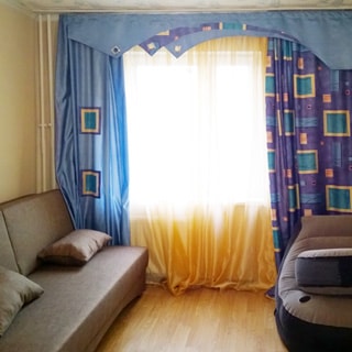 На фото: комната с окном, диван, кресло, стены оклеены обоями, пол - ламинат
