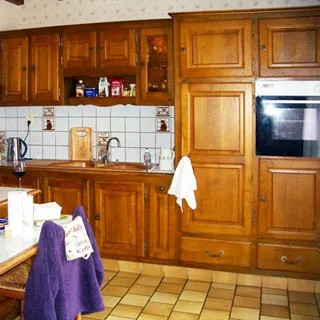 На фото: часть помещения кухни, кухонная рабочая поверхность с мойкой, встроенная кухонная мебель, навесные шкафы, встроенный духовой шкаф, кухонный фартук облицован плиткой, пол - плитка