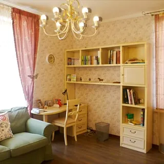 На фото: часть комнаты, два окна, письменный стол со стулом, книжные полки, мякгий диван, полы - ламинат, на потолке - люстра.