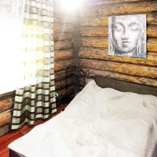 На фото: часть помещения спальни, одно окно, справа у стены - двуспальная заправленная кровать, над кроватью - эстамп, стены - бревенчатые, полы - ламинат