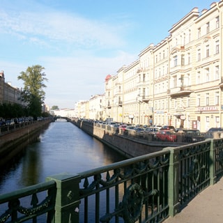 На фото: вид с моста на канал Грибоедова в сторону Вознесенского проспекта, справа на набережной - припаркованные автомобил, слева - высокие деревья