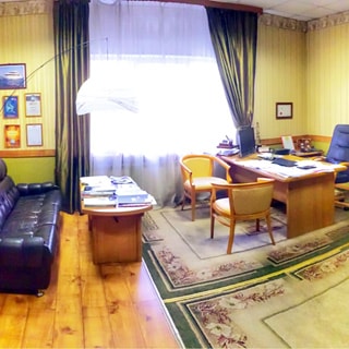 На фото: внутреннее помещение с окном и офисной мебелью - письменные столы, стулья, кресло, диван, на полу - ковер