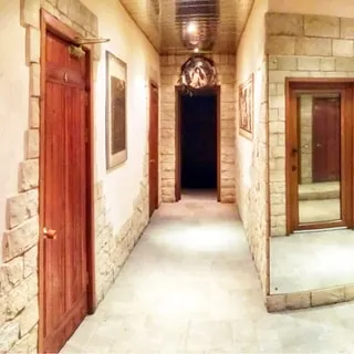 На фото: коридор, стены декорированы камнем, зеркалами, полы - плитка