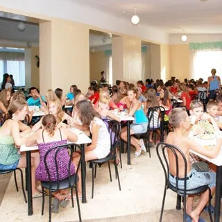 На фото: обеденный зал во время приема пищи детьми, столы на 4 человека