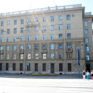 Фото сделано с Благодатной улицы. На фото: часть фасада кирпичного дома сталинского типа с элементами декора и балконами, тротуар и проезжая часть улицы.