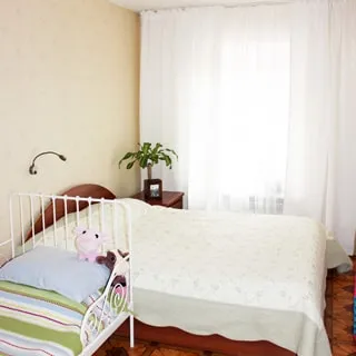 На фото: комната, одно окно, двуспальная кровать, детская кровать, тумбочка, полы - линолеум