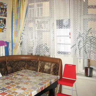 На фото: кухня, мягкий кухонный уголок, детский стул, два окна, в окне - стена дома напротив