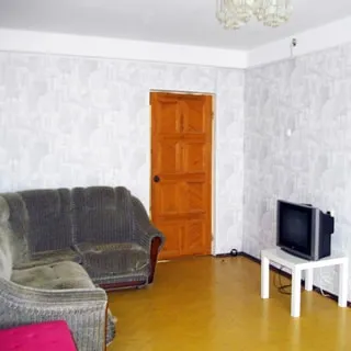 На фото: комната, полы - паркет, стены оклеены обоями, диван, столик с телевизором