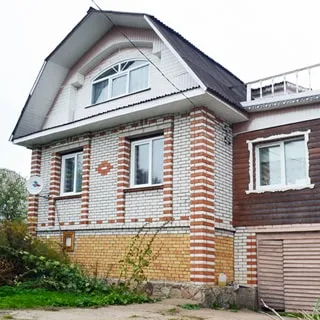 На фото: одноэтажный загородный дом с деревянной пристройкой, с подвалом и мансардой, облицован кирпичом и сайдингом, окна - стеклопакеты