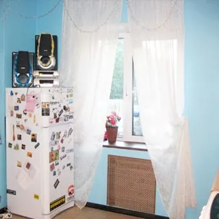 На фото: кухня, полы - плитка, двухкамерный холодильник, окно - на улицу, установлены стеклопакеты, стены - окрашены в голубой цвет