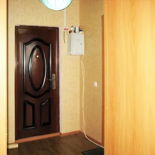 На фото: прихожая, металлическая выходная дверь, справа от двери - ящик электрощитка, полы - линолеум, стены оклеены обоями