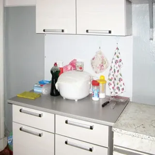 На фото: часть кухни, кухонный стол-тумба, скороварка, навесной шкаф.