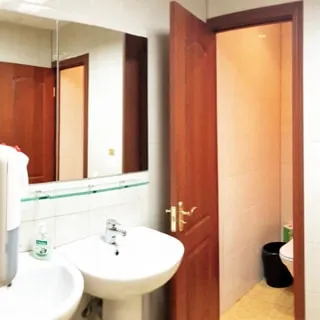 На фото: часть помещения санузла, два туалета, два умывальника, перед умывальниками слева на стене - зеркало
