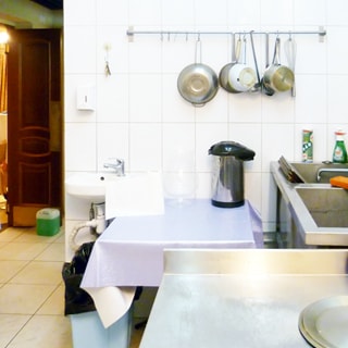 На фото: часть помещения для мойки посуды, стены облицованы плиткой, прямо у стены установлена раковина со смесителем для персонала, справа у стены ванны для мойки посуды, слева - проход в соседнее помещение