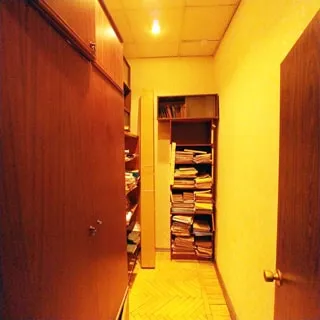 На фото: часть помещения офисного типа, прямо и слева у стен - стеллажи и шкафы для документов, полы - паркет, потолки - подвесные, установлены точечные светильники