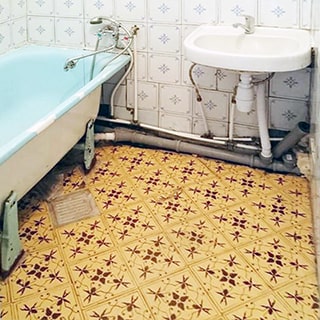 На фото: часть помещения ванной комнаты, слева вдоль стены полноразмерная ванна со своим смесителем, справа от нее - керамическая раковина со своим смесителем, полы и стены облицованы плиткой