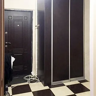 На фото: часть помещения прихожей, прямо - металлическая входная дверь, справа от нее - шкаф-купе, полы - линолеум, стены оклеены обоями
