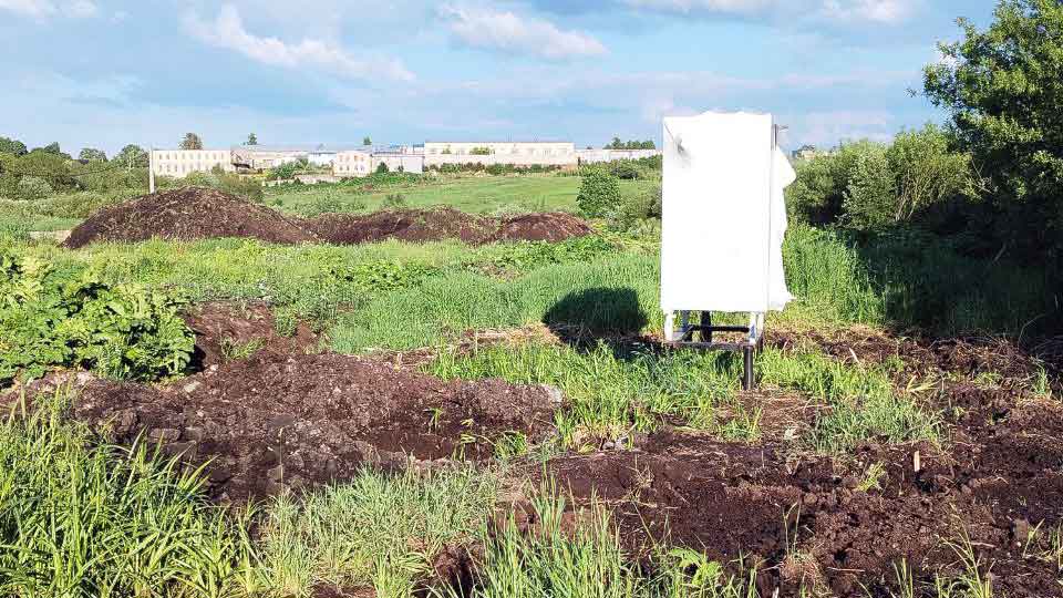 На летнем фото: газовый шкаф, расположенный на левой границе нашего участка, полевой ландшафт, на дальнем плане малоэтажная застройка