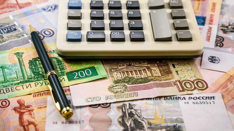 На фото: калькулятор, бумажные деньги, ручка.